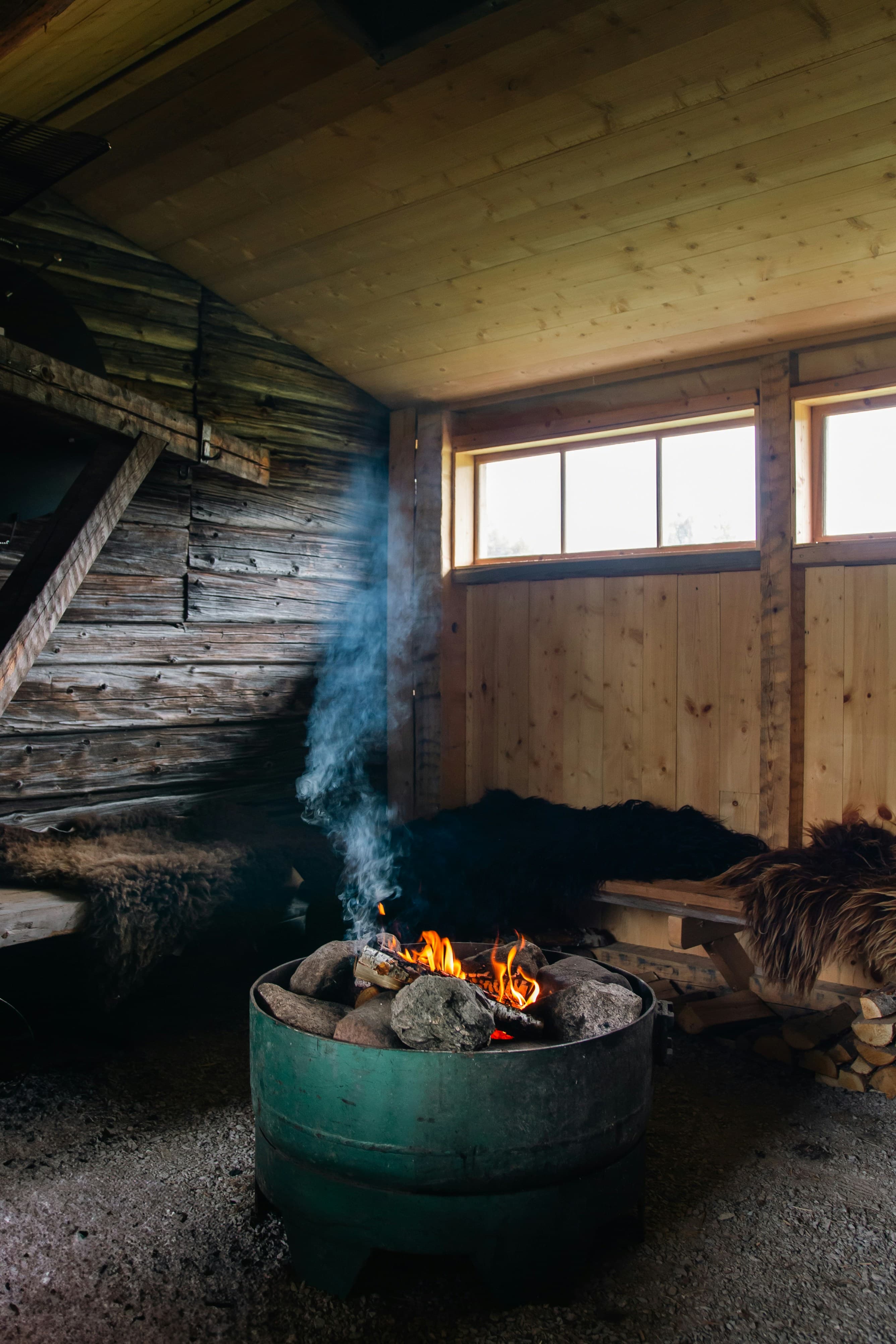 Hoguera ardiendo dentro de un refugio rústico de madera.